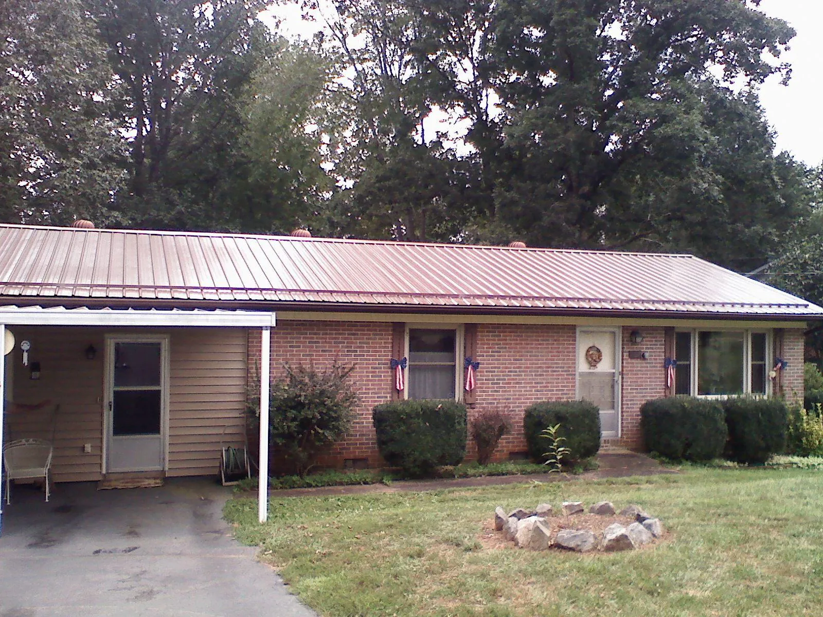 Bronze metal roof and carport on a brick ranch home — Roof Repair work by our crew in Watkins