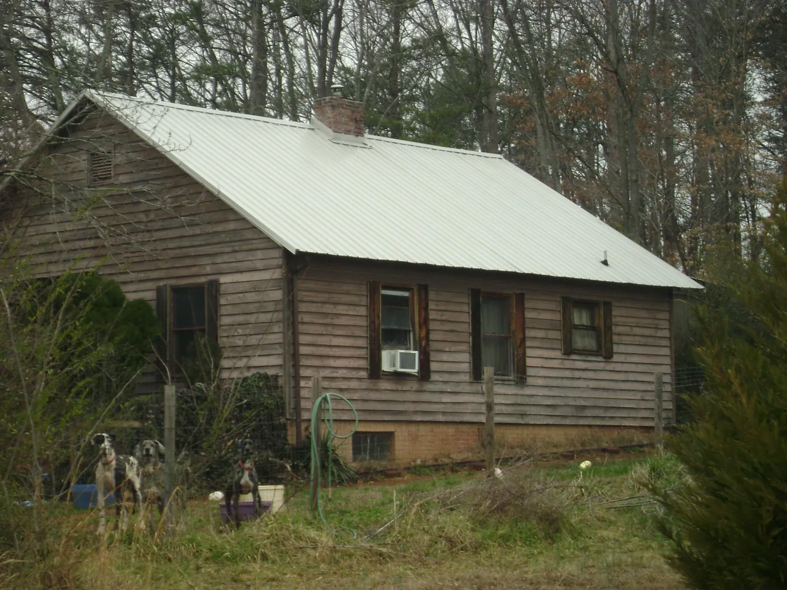 White metal roof on an old wood sided farmhouse, from a Metal Roof Installation job in Watkins